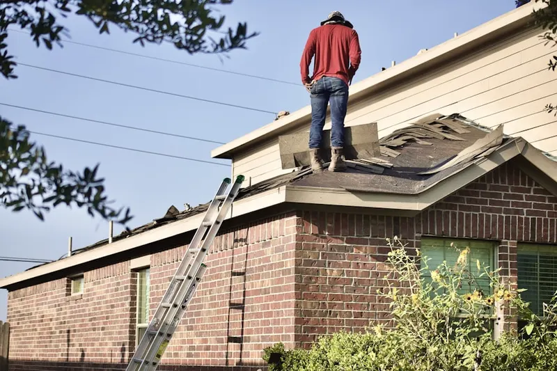 Professional roofer working on a residential roof in East Dundee
